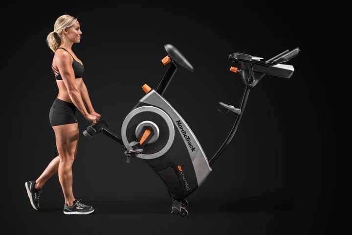 NordicTrack GX 4.4 Pro Exercise Bike with a female model moving the machine