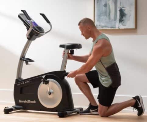 NordicTrack GX 4.5 Pro Exercise Bike - with a male model adjusting the seat