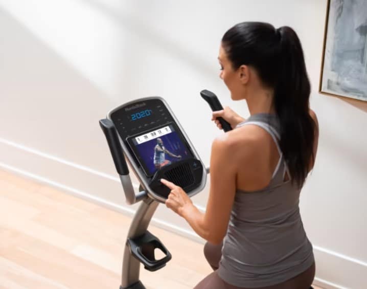 NordicTrack GX 4.5 Pro Exercise Bike - with a female model setting up the console