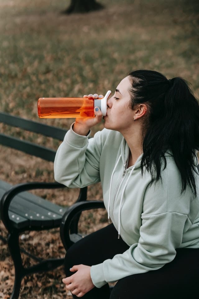 A female runner drinking water 