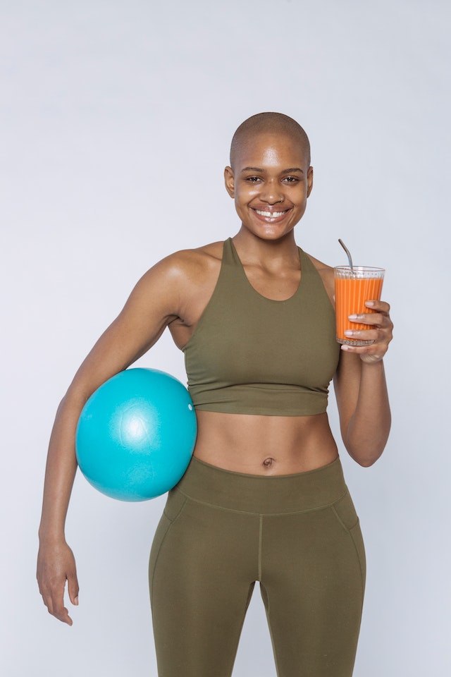 sportswoman with smoothie and ball