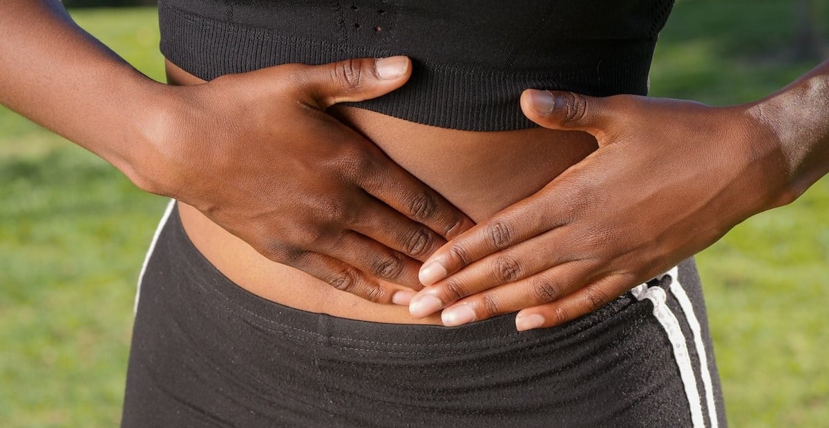 A woman touching her abdomen
