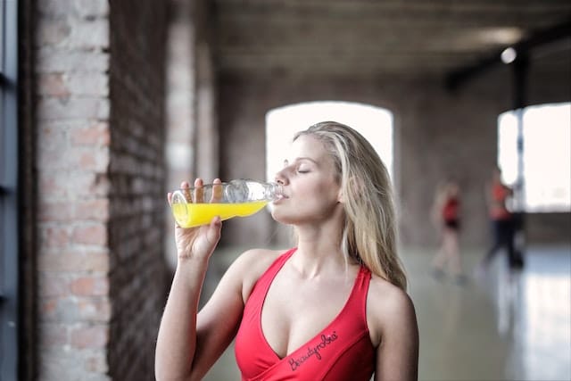 Woman in Red Tank Top Drinking
