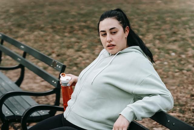 A female runner resting on bench after training in park
