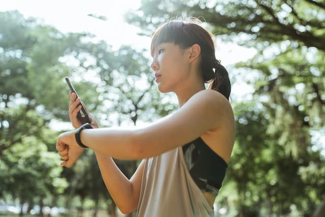 A woman using devices for fitness in park