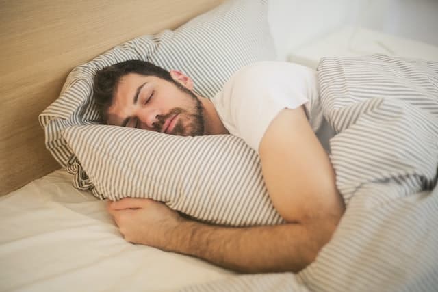 a man sleeping with pillows 