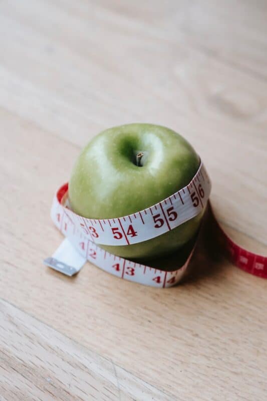 Green apple with measuring tape 