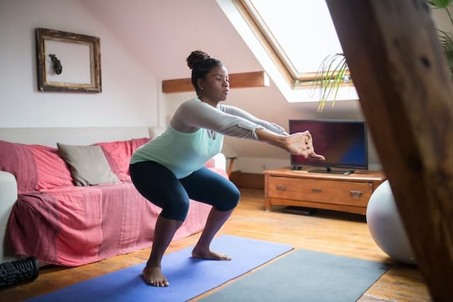 Woman doing sumo squat in a room