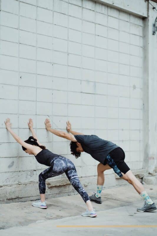 two people stretching before running