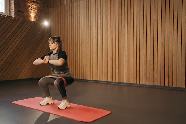 Woman Doing the Squats with a Resistance Band
